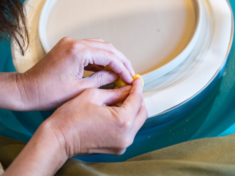A closeup of clay being shaped on a pottery wheel.
